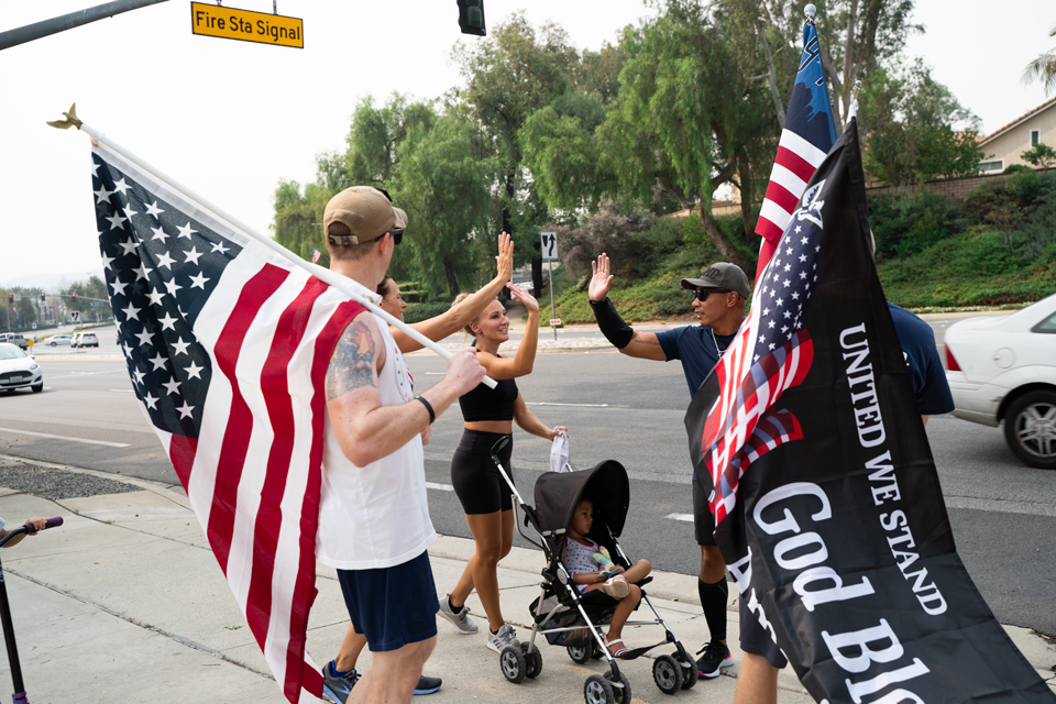 People walking together holding american flags