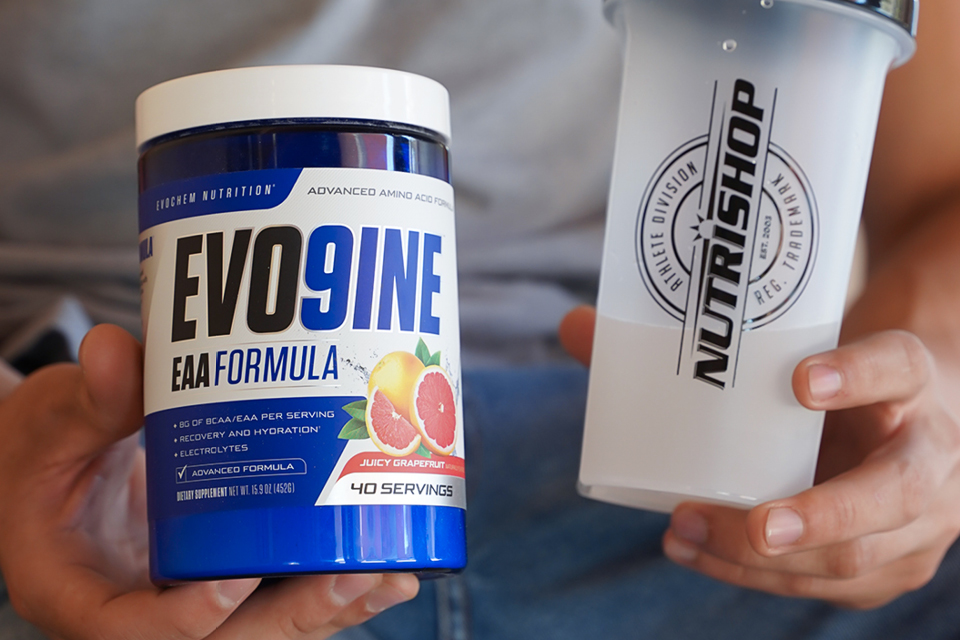 Close up of hands holding Evo Nine in one hand and a nutrishop shaker bottle in the other