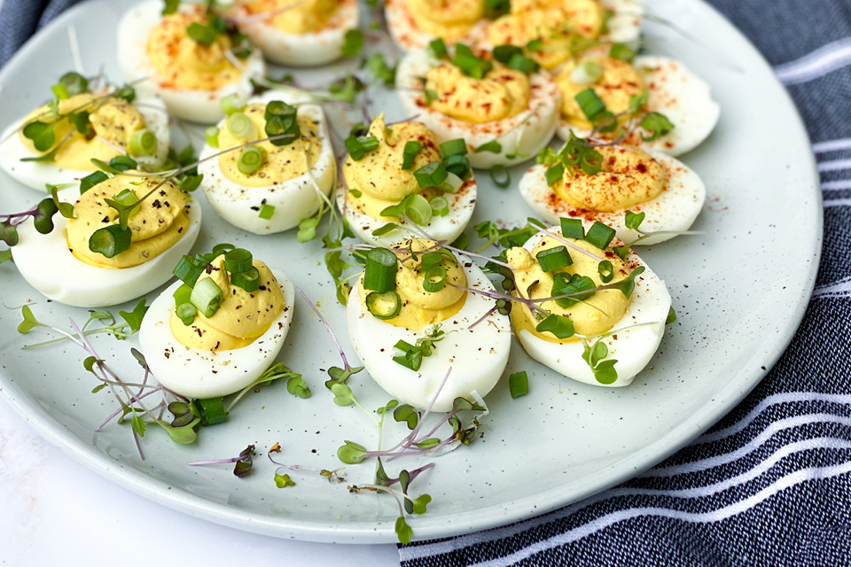 Platter of deviled eggs topped with green onion slices