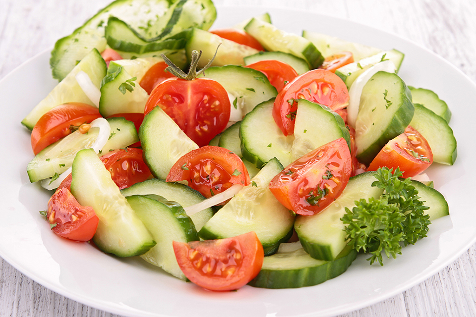 Bowl of cucumbers , tomatoes and onions