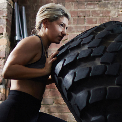 Woman lifting a giant tire