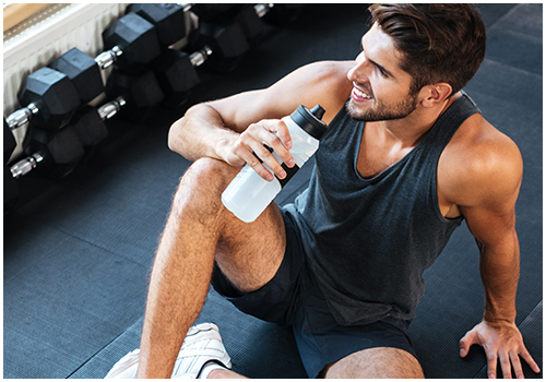 Smiling man on sitting on the floor at the gym