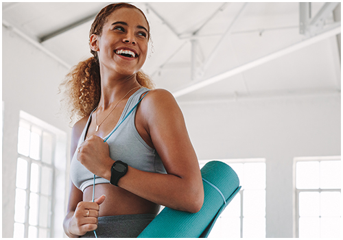 Smiling woman holding a yoga mat