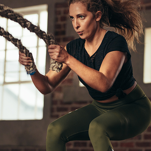 Woman doing battle rope waves exercise