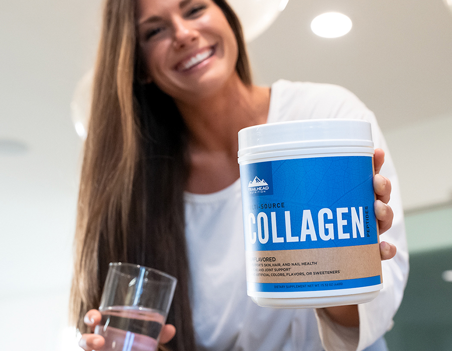 Smiling woman holding collagen container