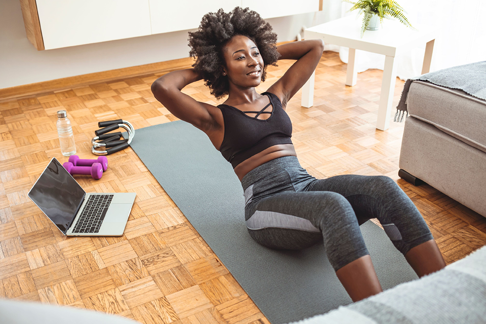 Image of black woman doing situps at home