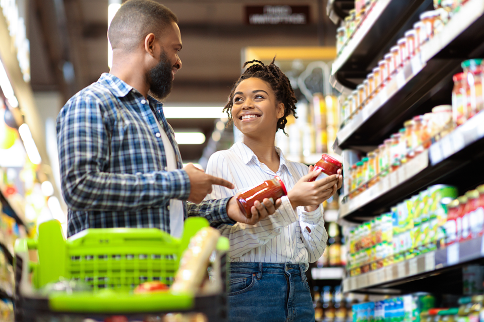 a couple reading labels at the grocery store