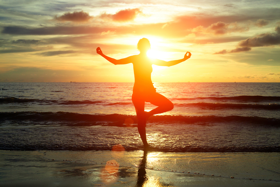 Woman doing yoga at the beach