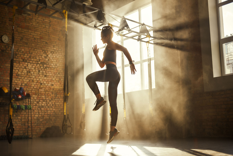 Woman in gym doing high jumps