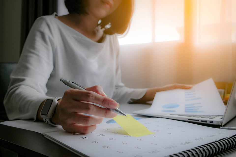 Woman writing in calendar