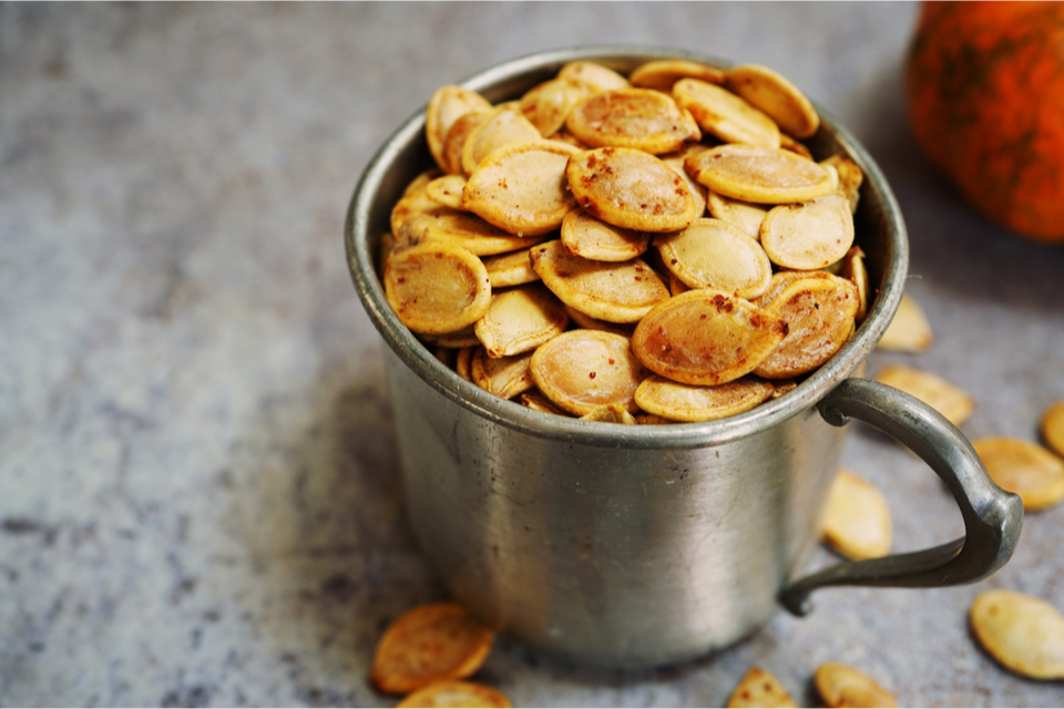 Mug full of roasted pumpkin seeds