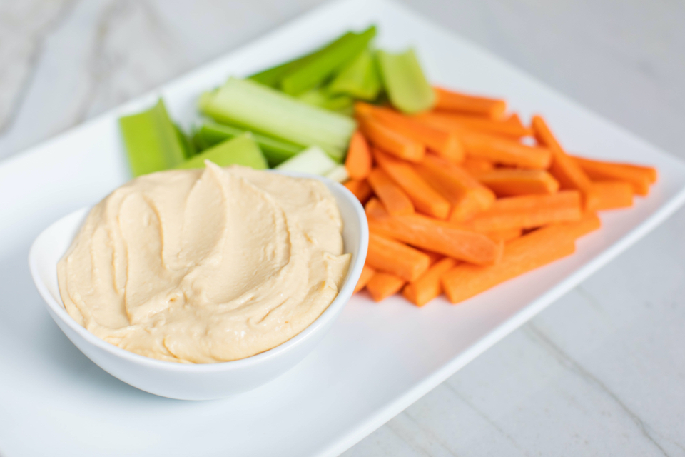 plate of slides carrots and celery with a side of hummus