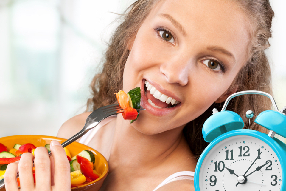 Woman smiling while eating a salad