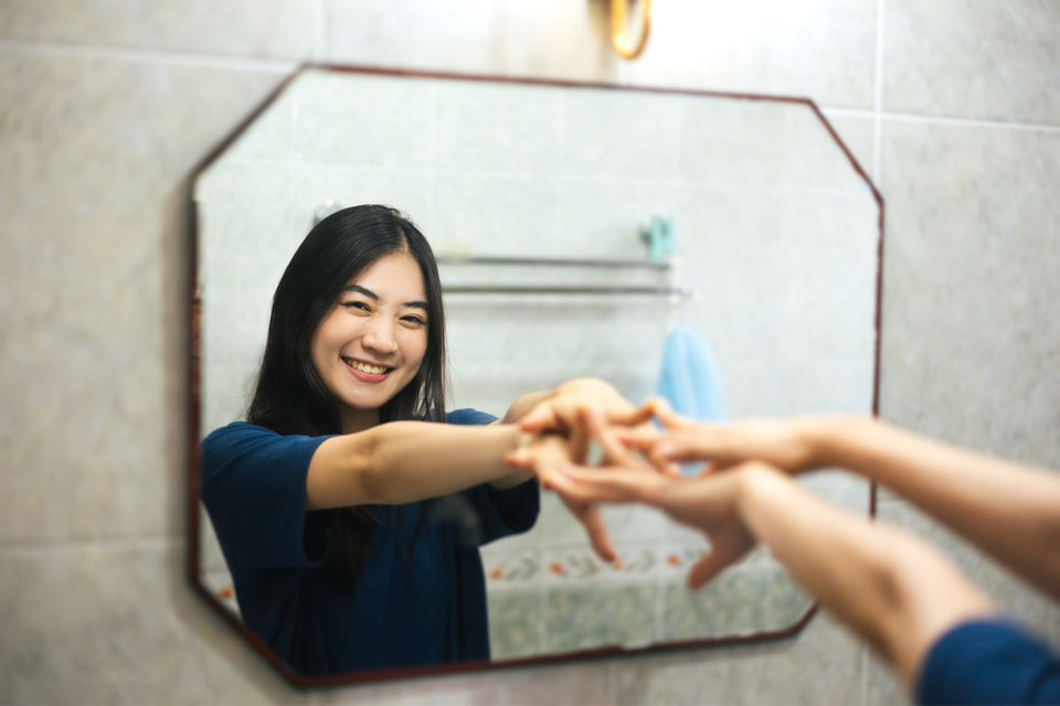 Woman smiling at herself in the mirror