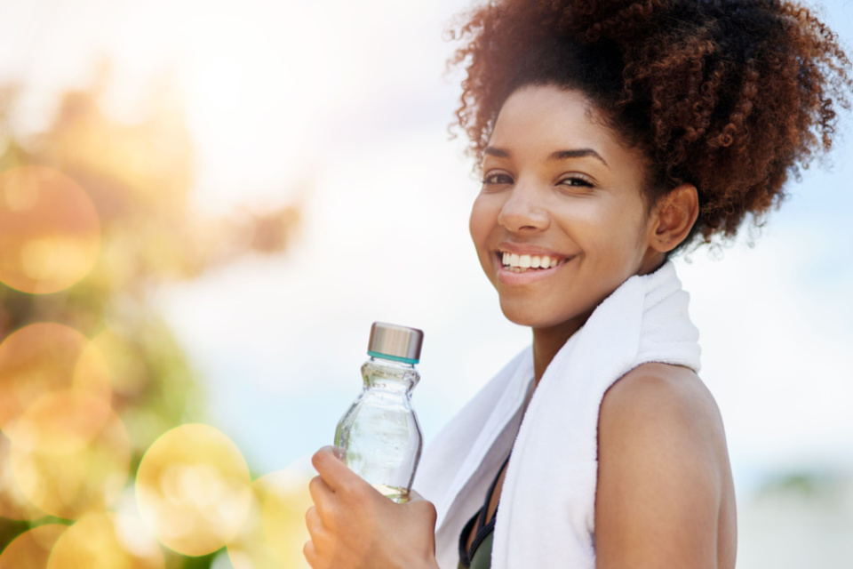 Women smiling with a water bottle in her hand