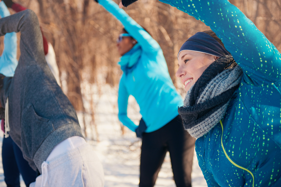 Group of people stretching in the snow