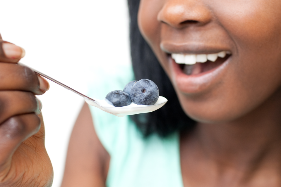 Woman about to eat a spoonful of yogurt with blueberries