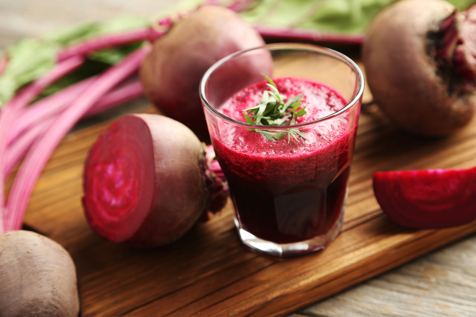 Cup of beet juice with beets in the background