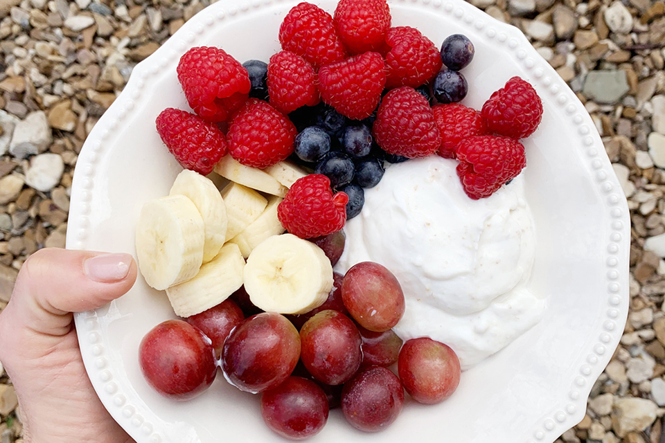 Bowl of berries, banana slices, grapes and greek yogurt