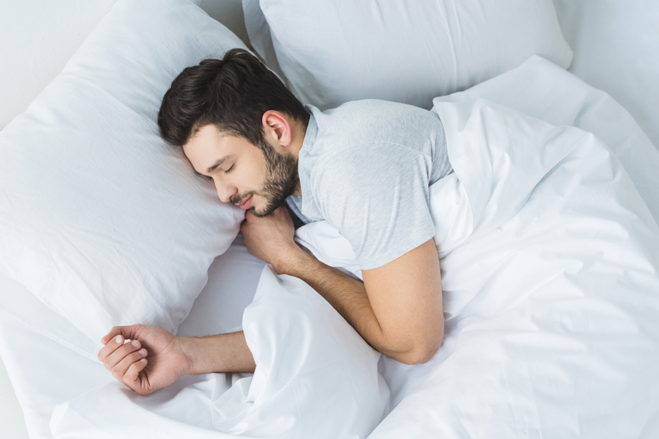 Man happily sleeping in bed