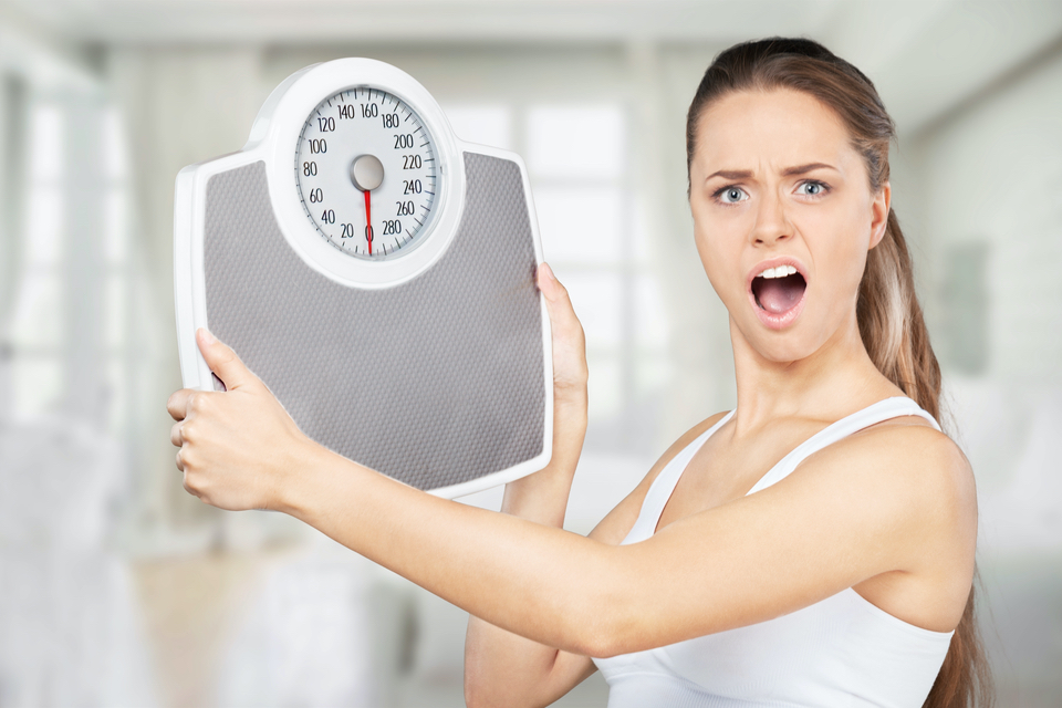 Upset woman holding a scale