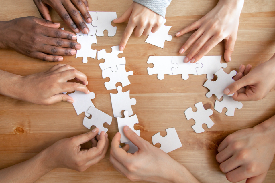 Hands putting a blank puzzle together