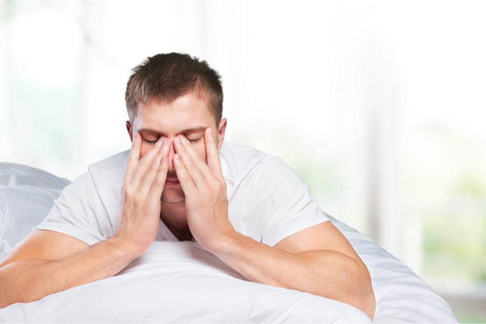 Stressed man putting his hands to his face