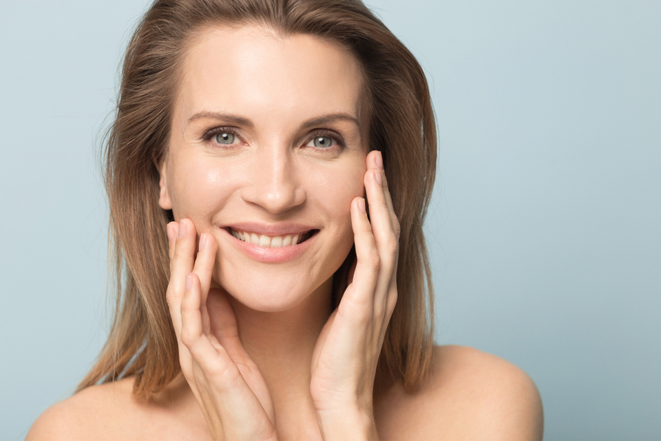 Smiling woman holding her face