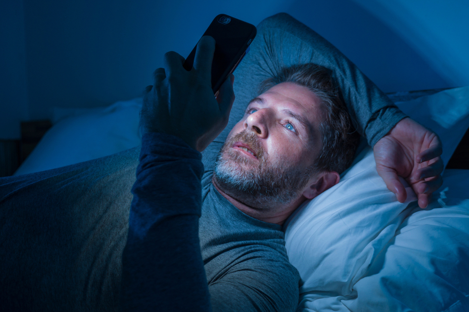 Person staring at phone in bed