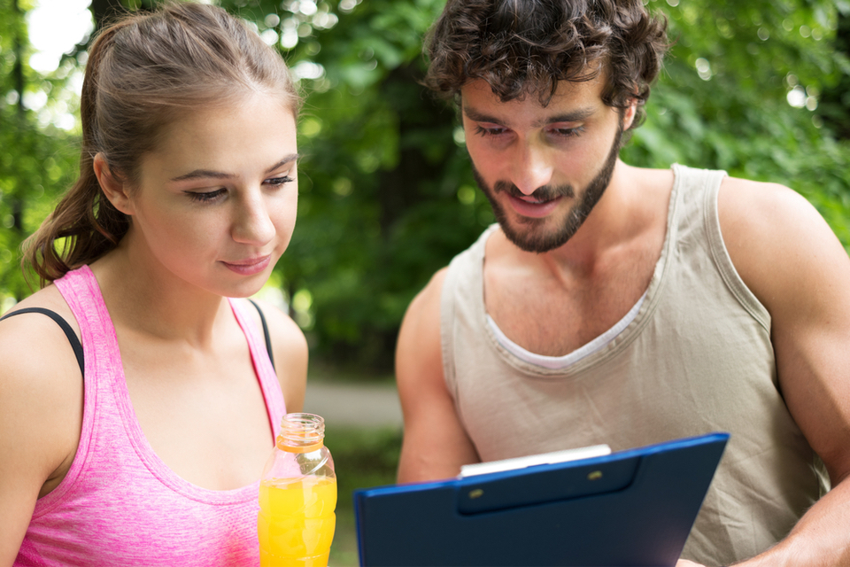 Man and woman looking at a click board