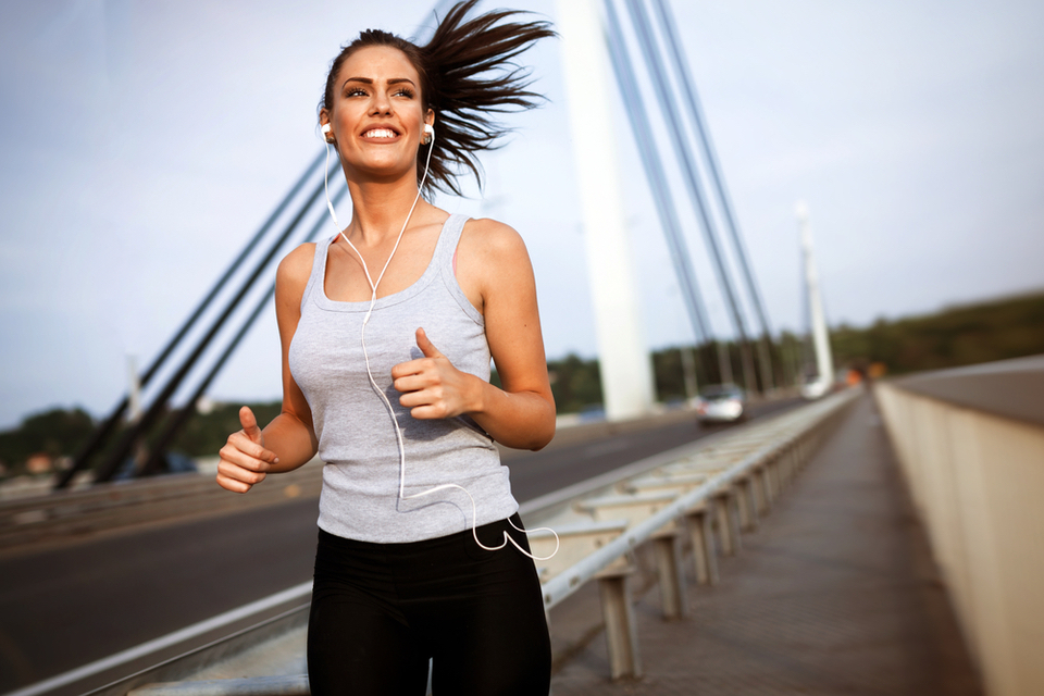 Woman happily running on a bridge