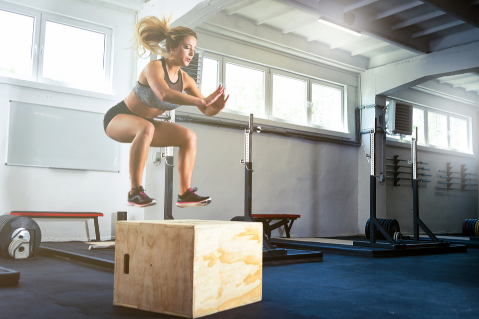 Woman mid air while doing box jumps