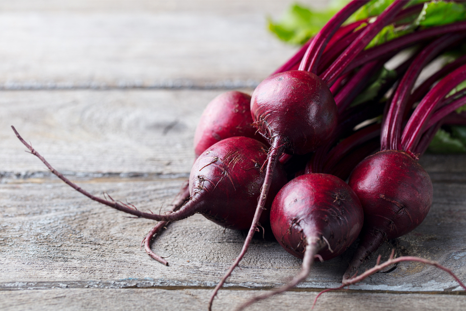 Raw beets on a wood surface