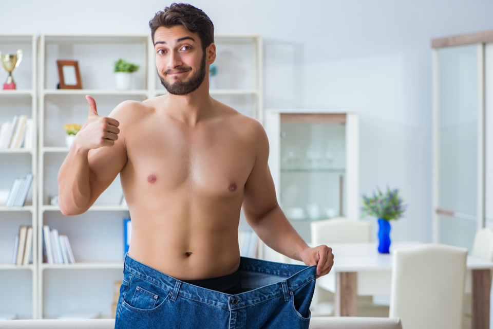 Shirtless man in oversized jeans