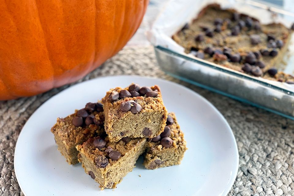 plate of Protein Pumpkin Blondies in fornt of a pumpkin