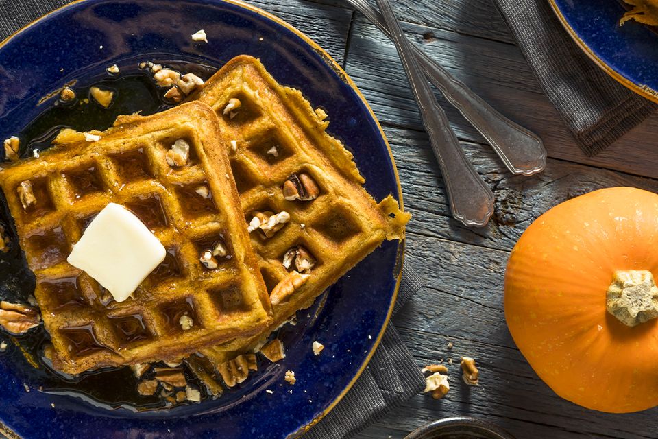 Plate of waffles with syrup and a slice of butter