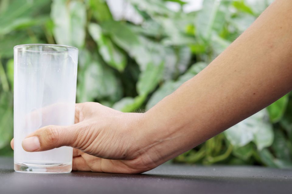 Hand holding an empty glass of milk