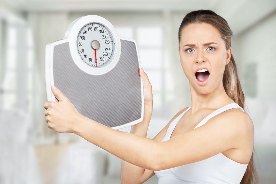 Upset woman holding a scale