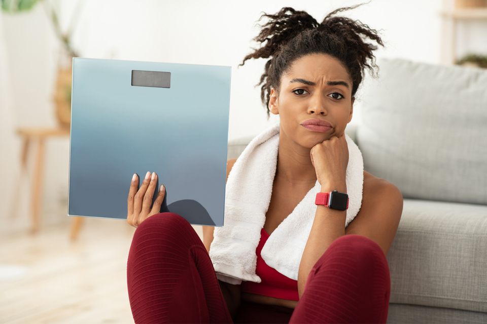 Upset woman holding a scale in her hand