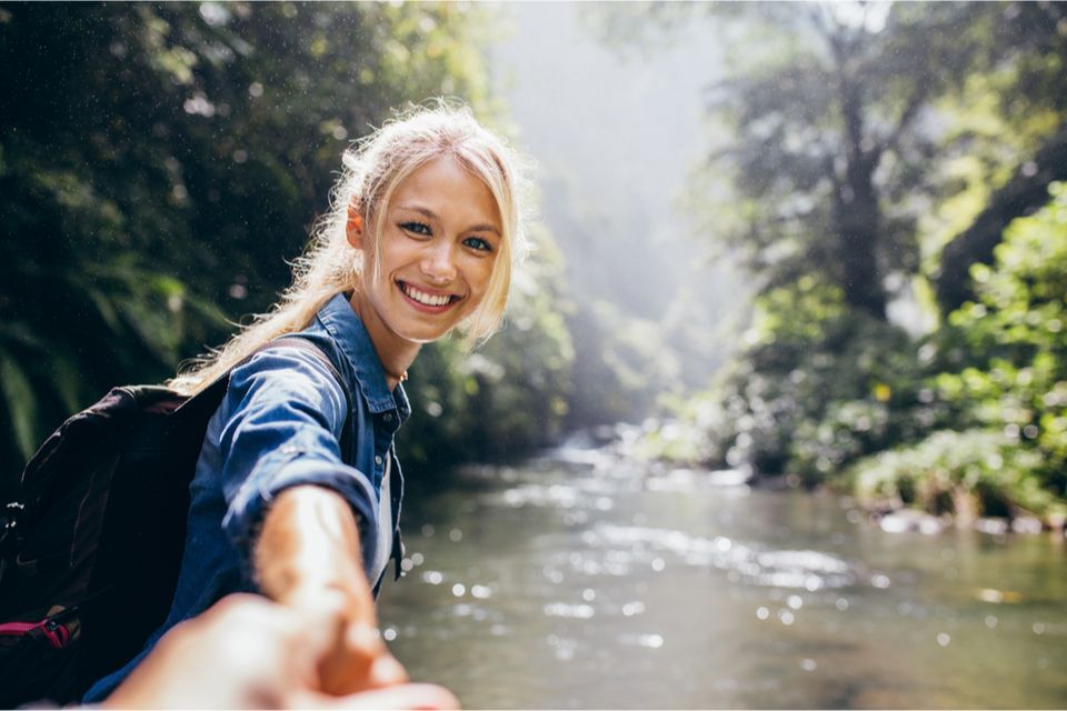 Woman hiking and smiling back at camera