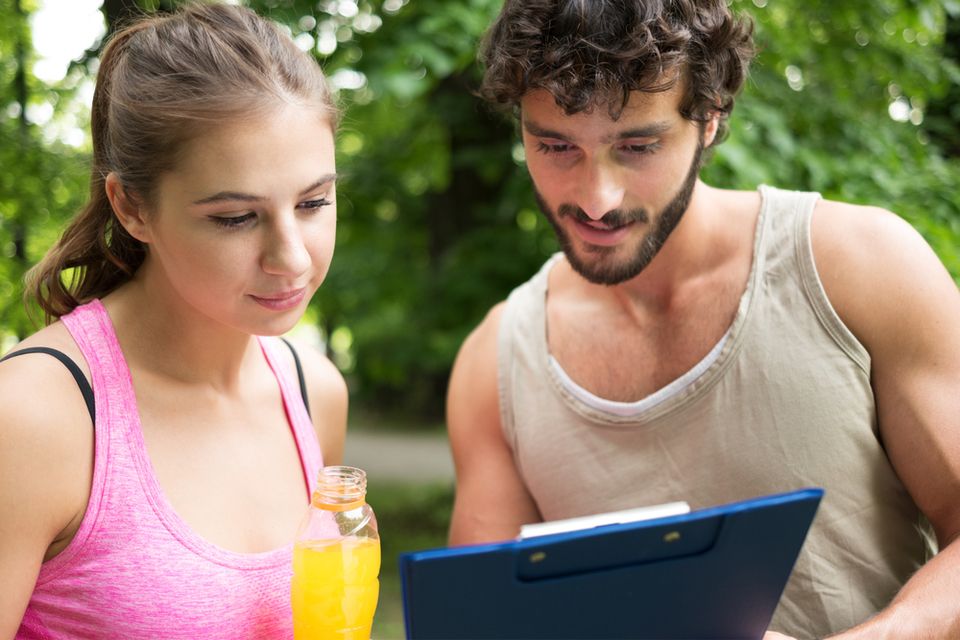 Man and woman looking at a click board