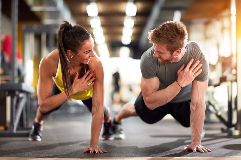 Woman and man doing push up shoulder taps together