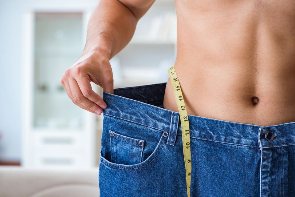 A man's torso in oversized jeans