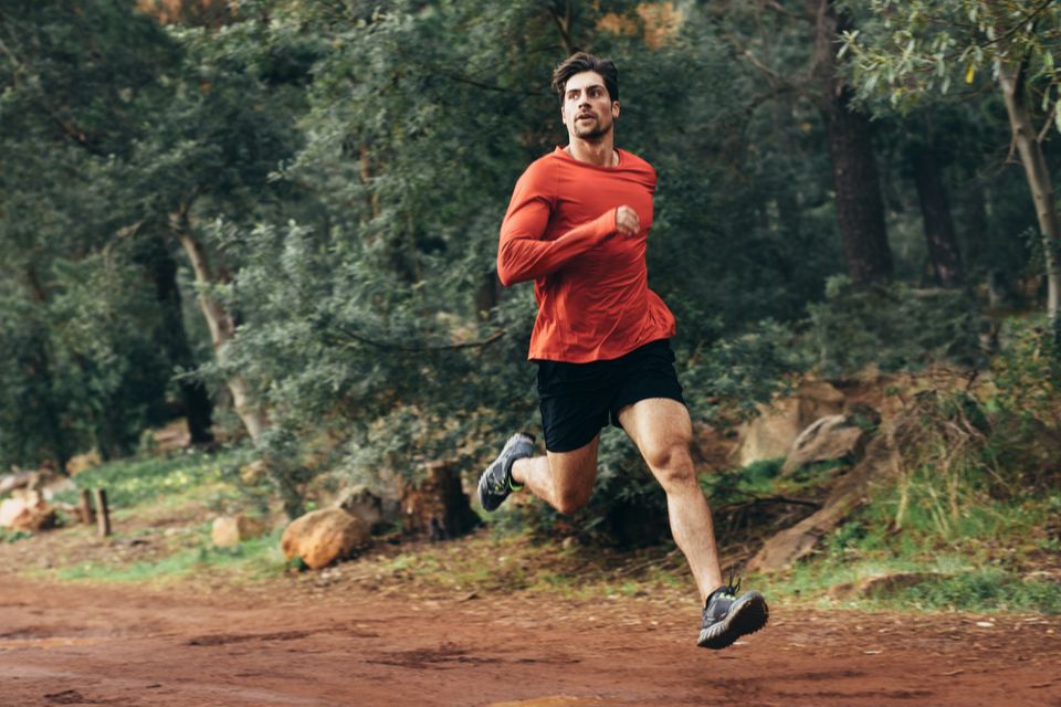 Man trail running, mid leap 