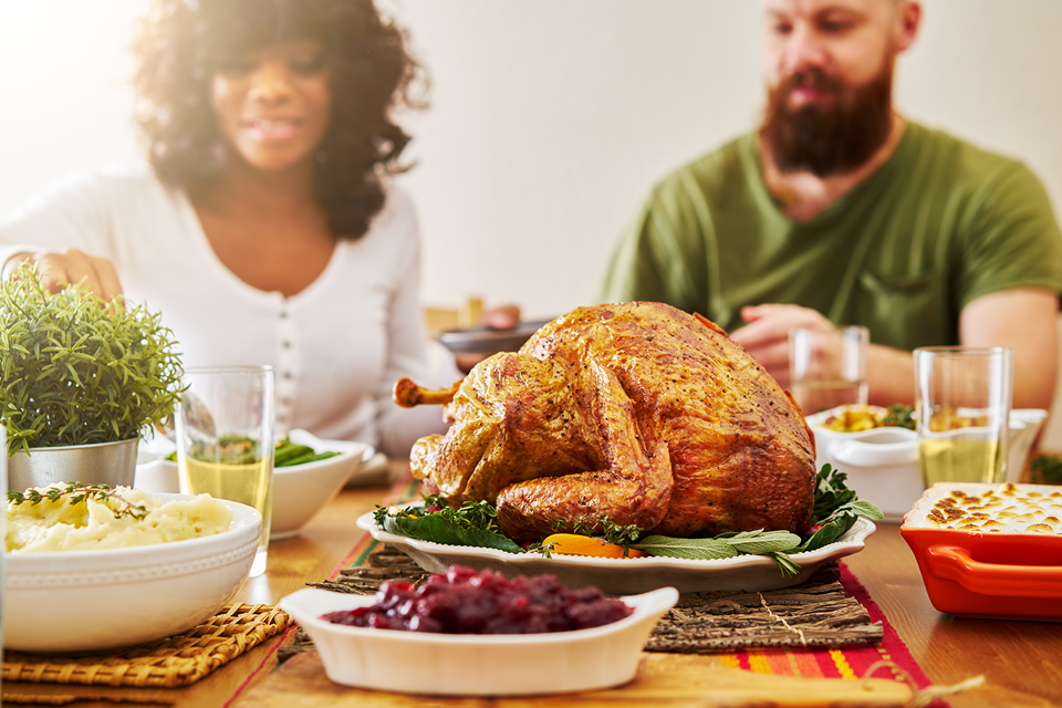 Friends about to eat a huge Thanksgiving spread.