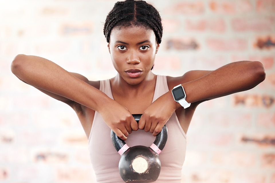 Young black woman lifting a kettlebell